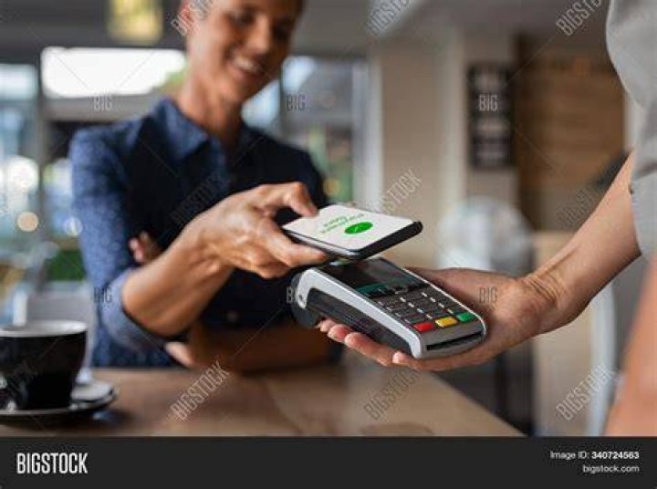 A woman paying contactless with credit card.