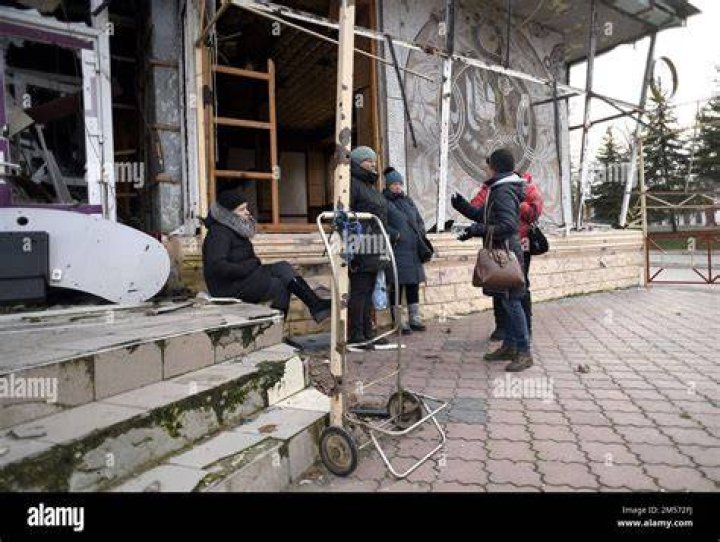 People stay next to destroyed cars after an explosion in Kerman, Iran, Wednesday, Jan. 3, 2024. Iran says bomb blasts at an event honoring a prominent Iranian general slain in a U.S. airstrike in 2020 have killed at least 103 people and wounded 188 others. (Tasnim News Agency via AP)