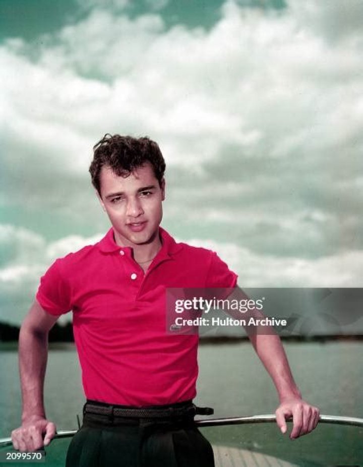Sal Mineo poses in a red Lacoste polo shirt aboard a boat, 1950s. | Source: Getty Images.
