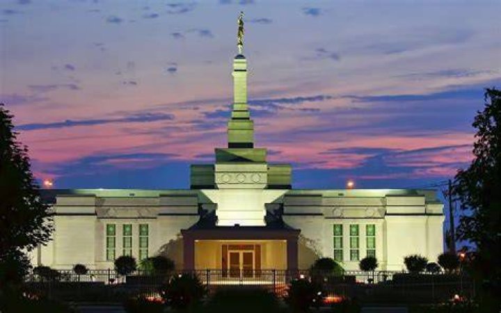 The Montreal Quebec Temple, a white building topped by a silver statue of an angel blowing a trumpet.