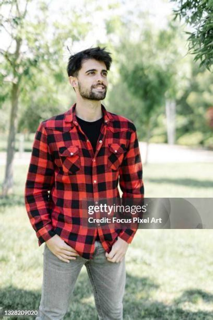 Young people wearing red flannel shirts linking arms and dancing.